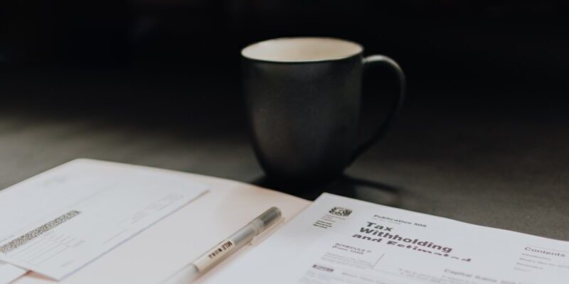 coffee mug near open folder with tax withholding paper